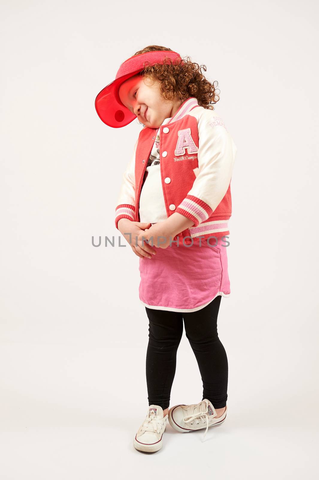 Little girl with red cap standing and smiling