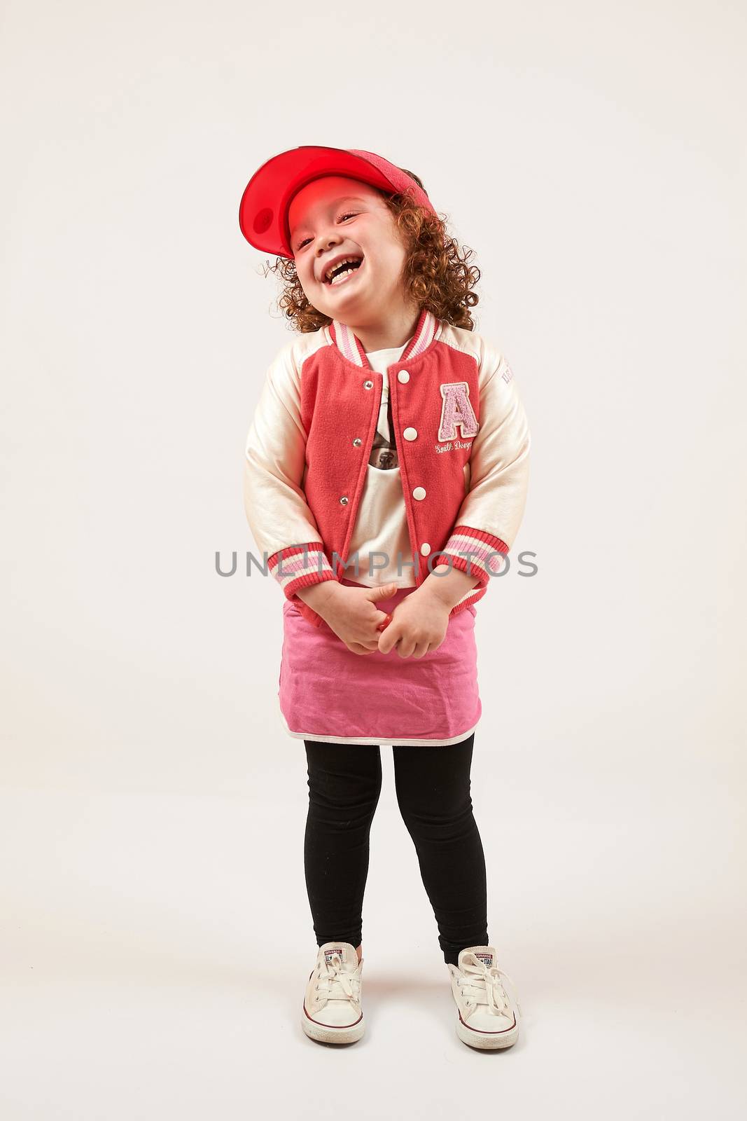 Little girl with red cap standing and smiling