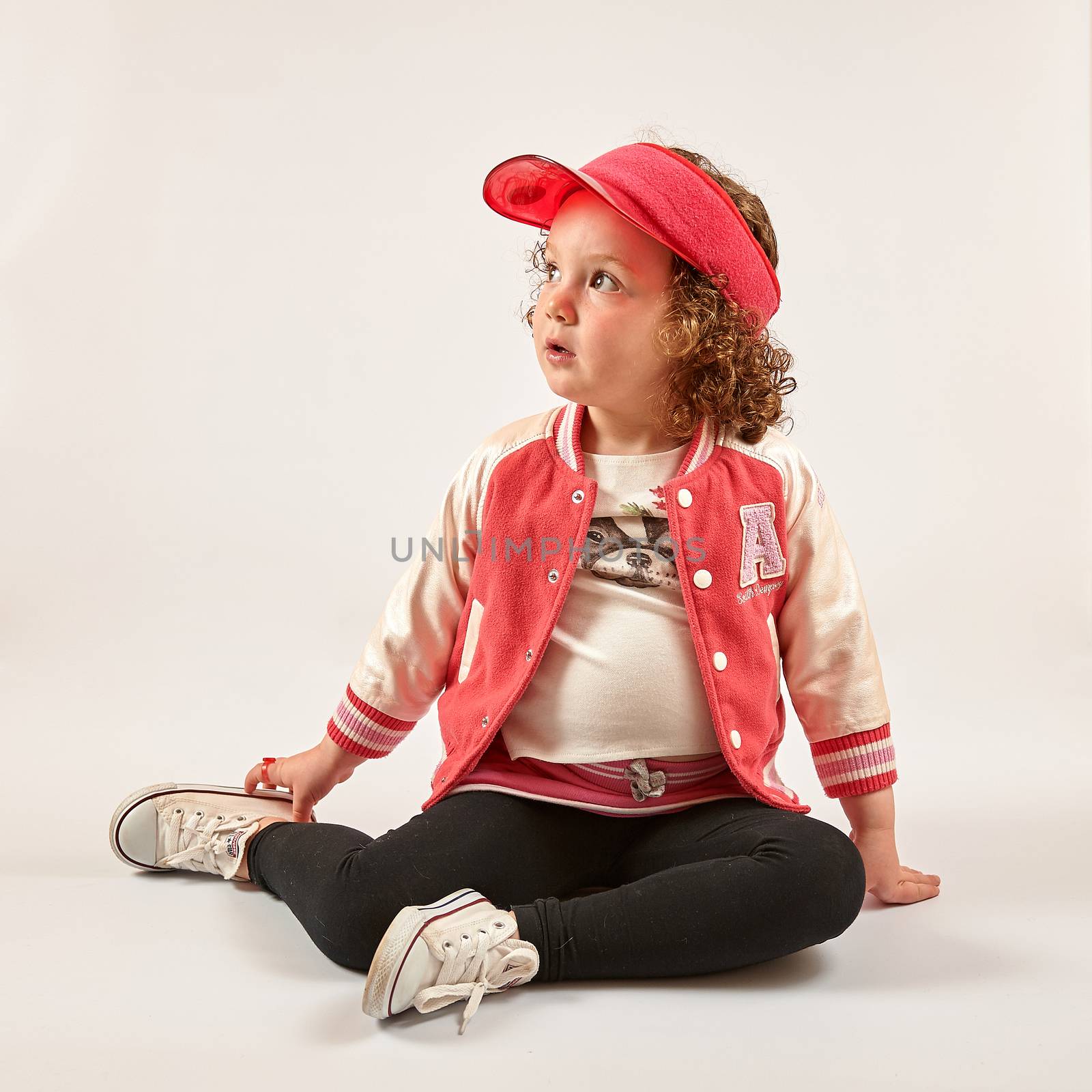 Little girl with red cap standing and smiling