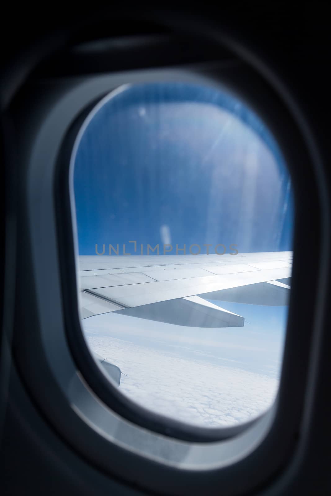 Clouds and sky as seen through window of an aircraft