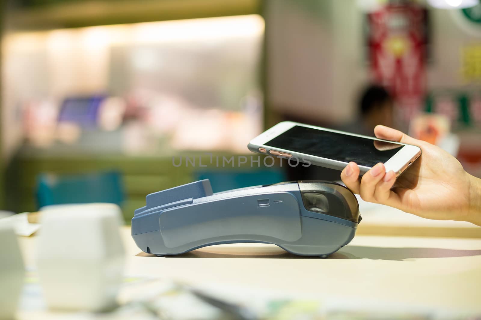 Customer paying with smartphone inside restaurant by leungchopan