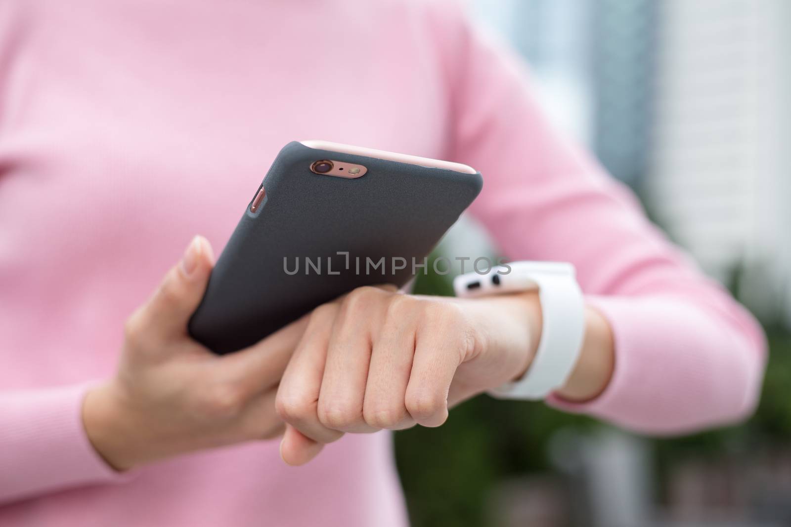 Woman using smart watch and connecting with cellphone