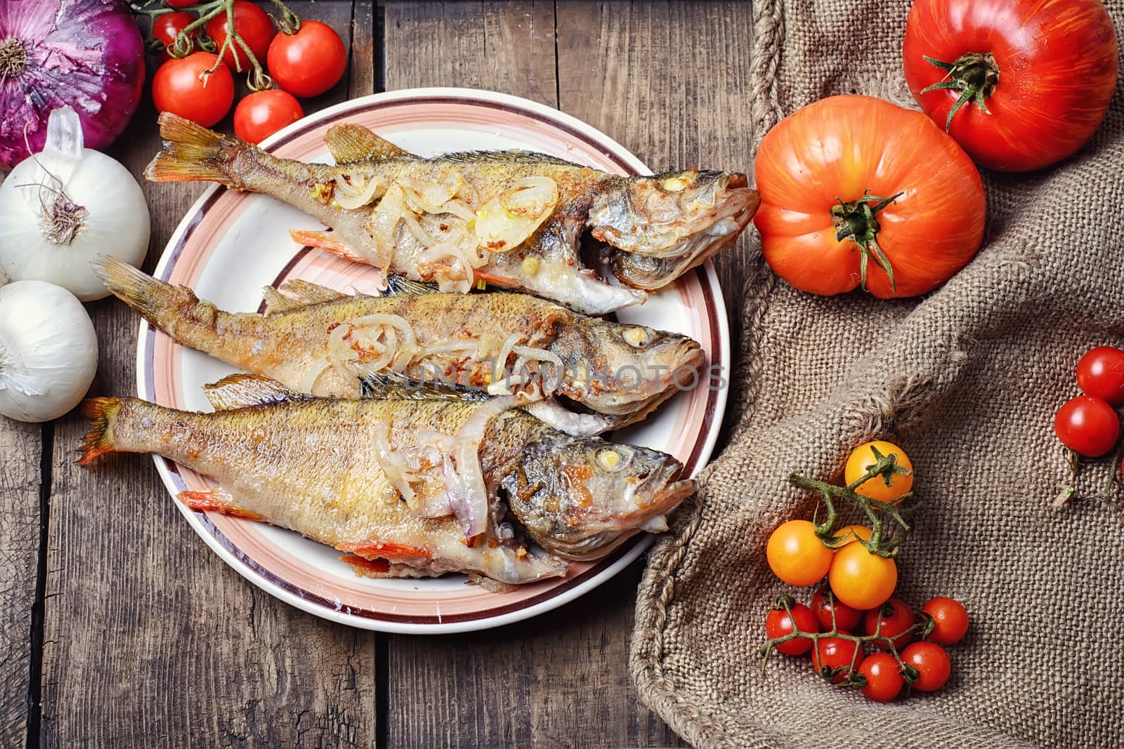 Dish of fried perch and vegetables on rustic recipe