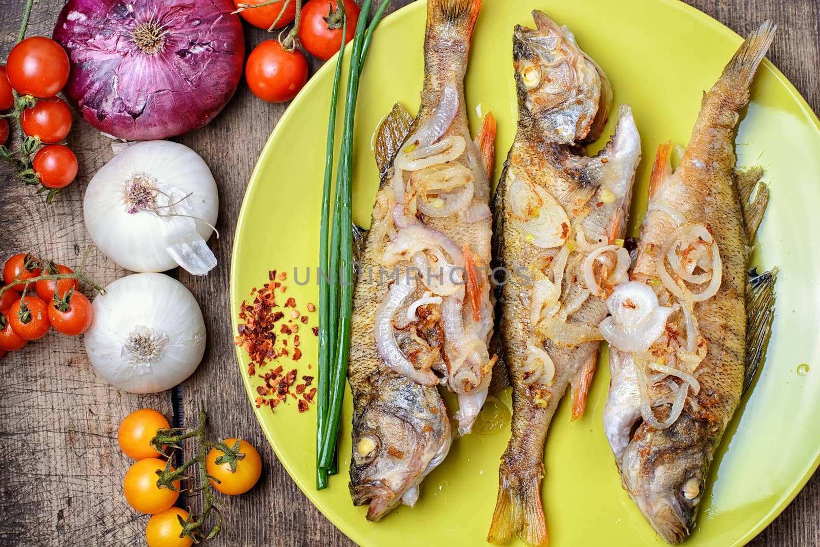 Dish of fried perch and vegetables on rustic recipe