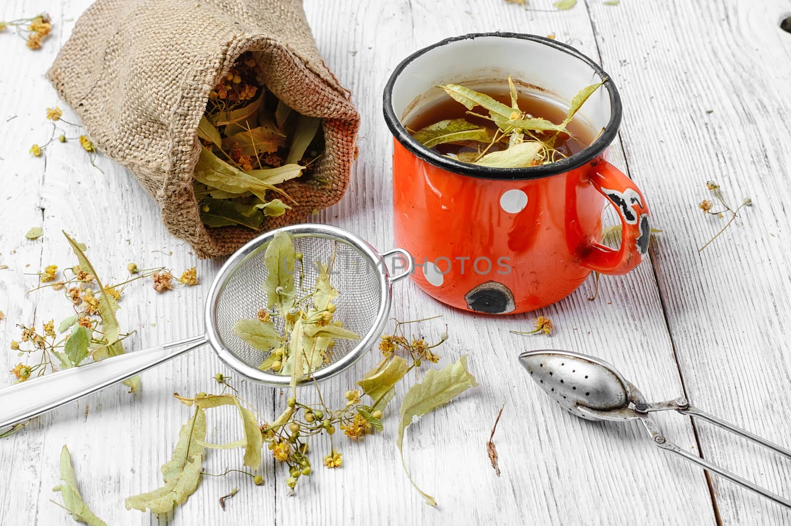 Iron mug of tea brewed with dried medicinal inflorescence of Linden