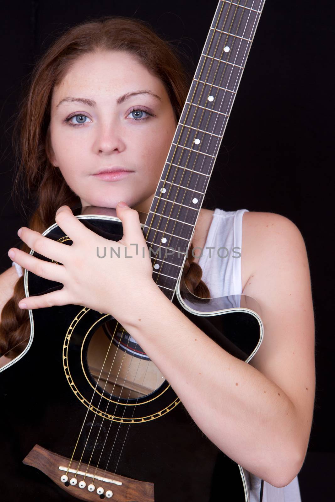 Beautiful woman with a guitar on a black background