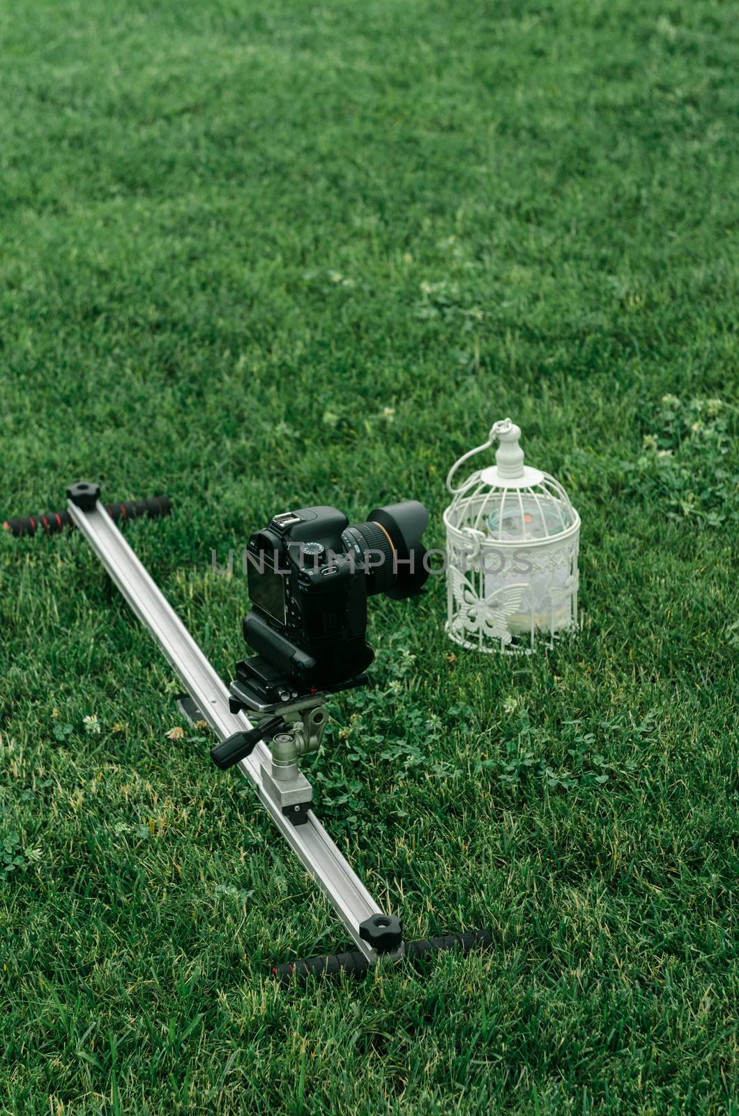 the camera on the rail stands on the grass opposite the white cell