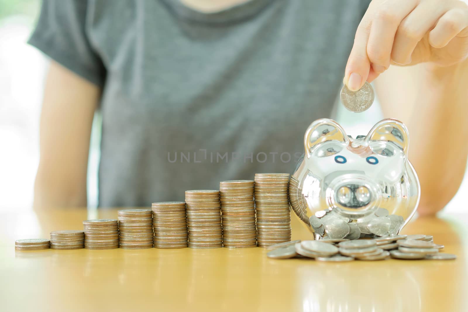 saving money-young woman putting a coin into a money-box-close up