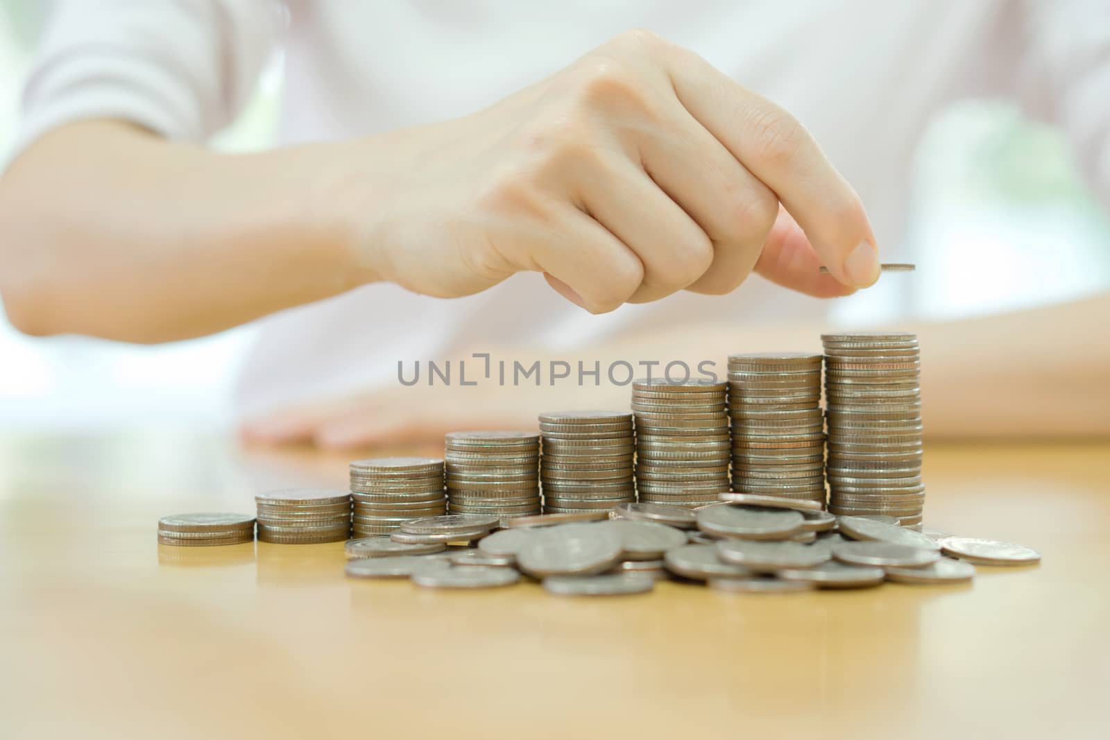 Hand put coins to stack of coins