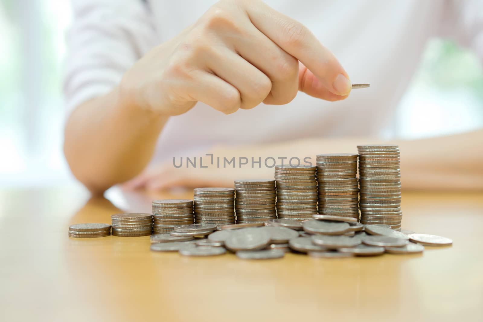 woman put coins to stack of coins