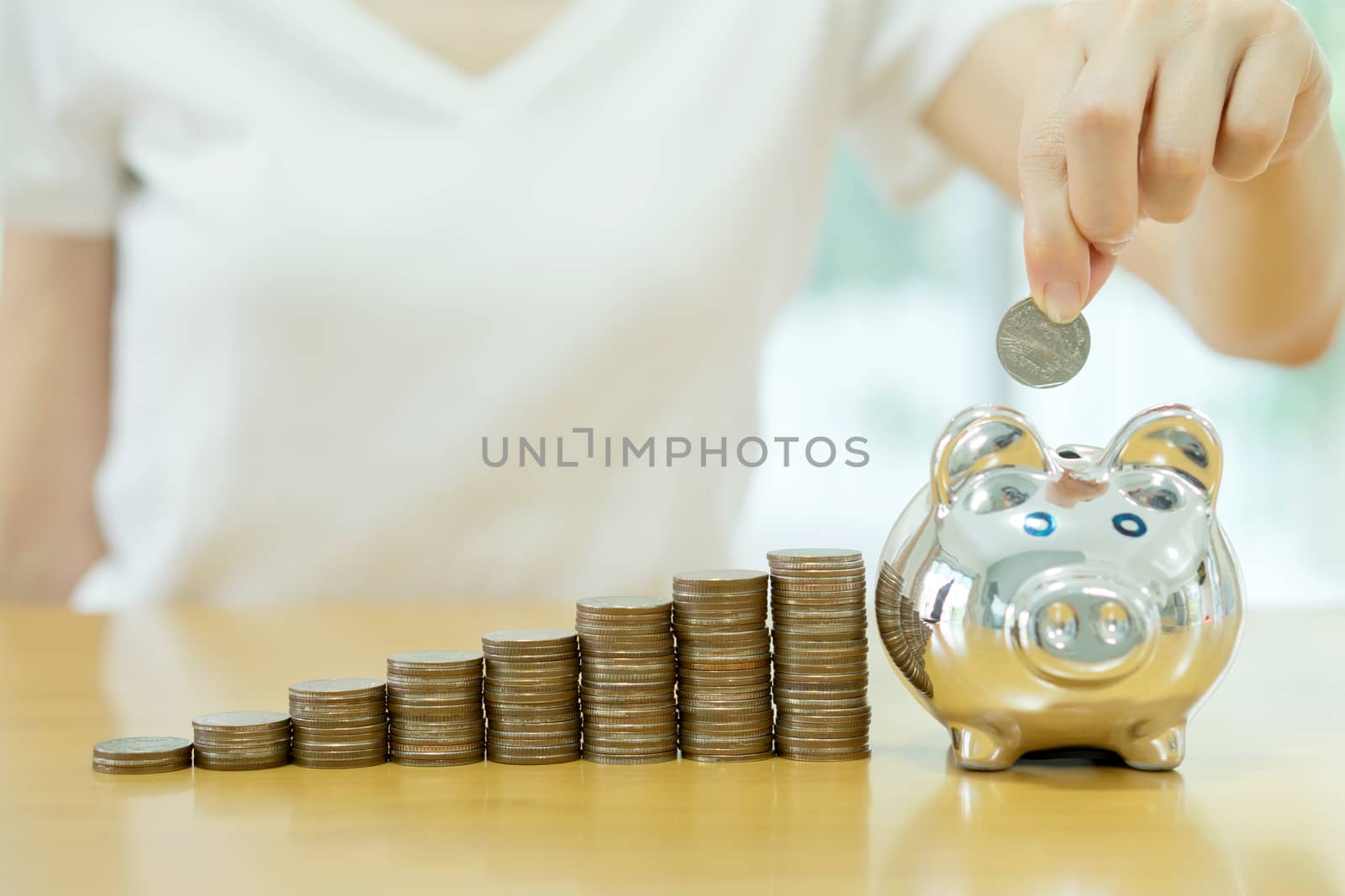 saving money-young woman putting a coin into a money-box-close up
