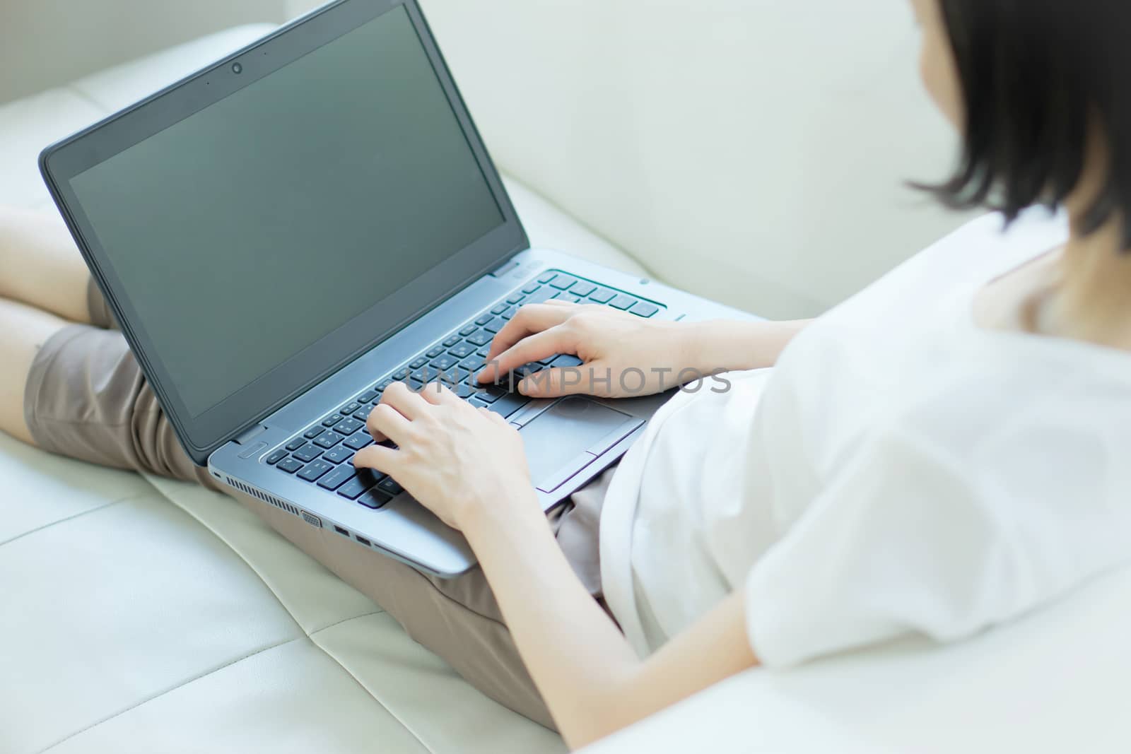 Casual young woman using laptop in living room at home
