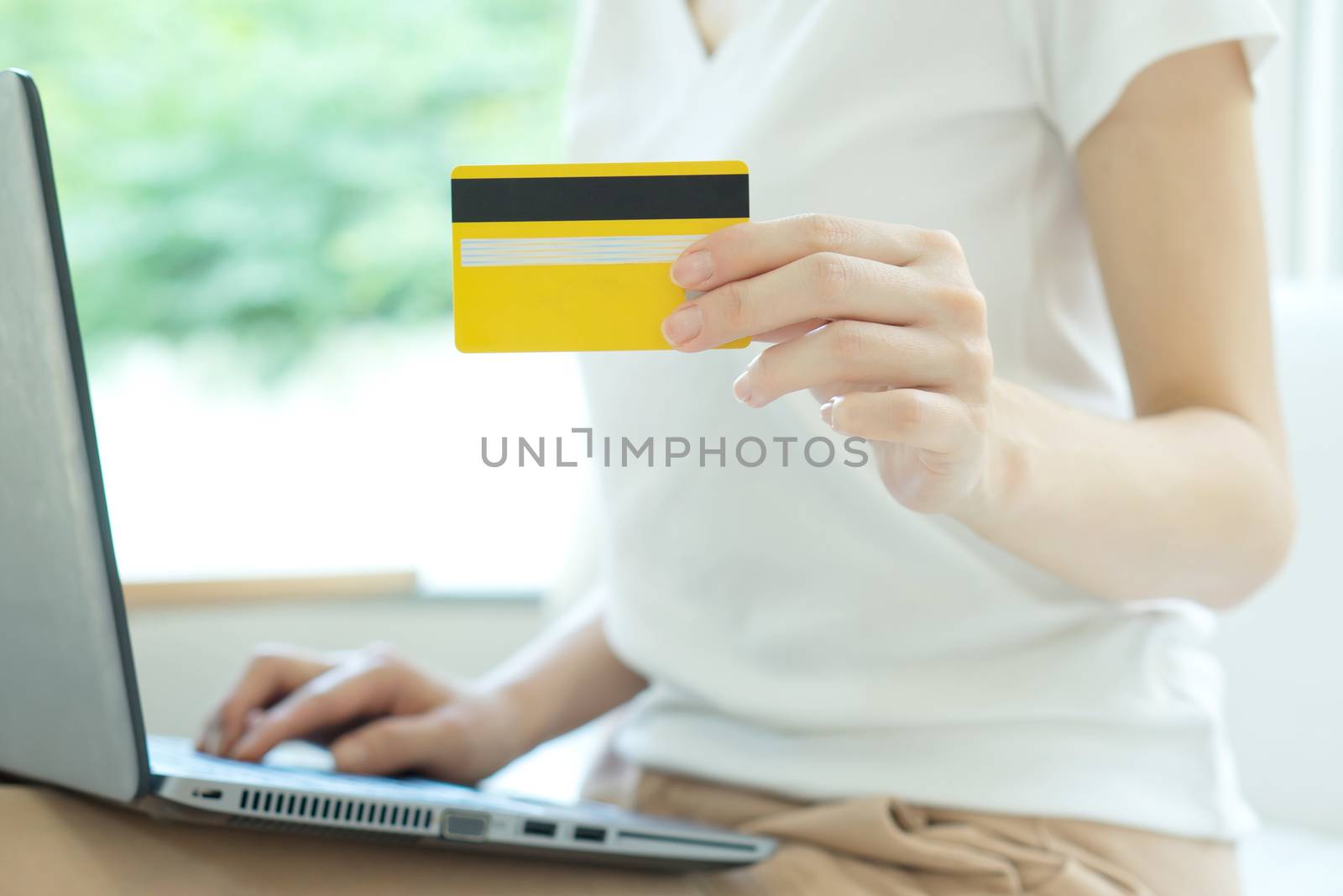 Young beautiful woman with laptop and credit card at home