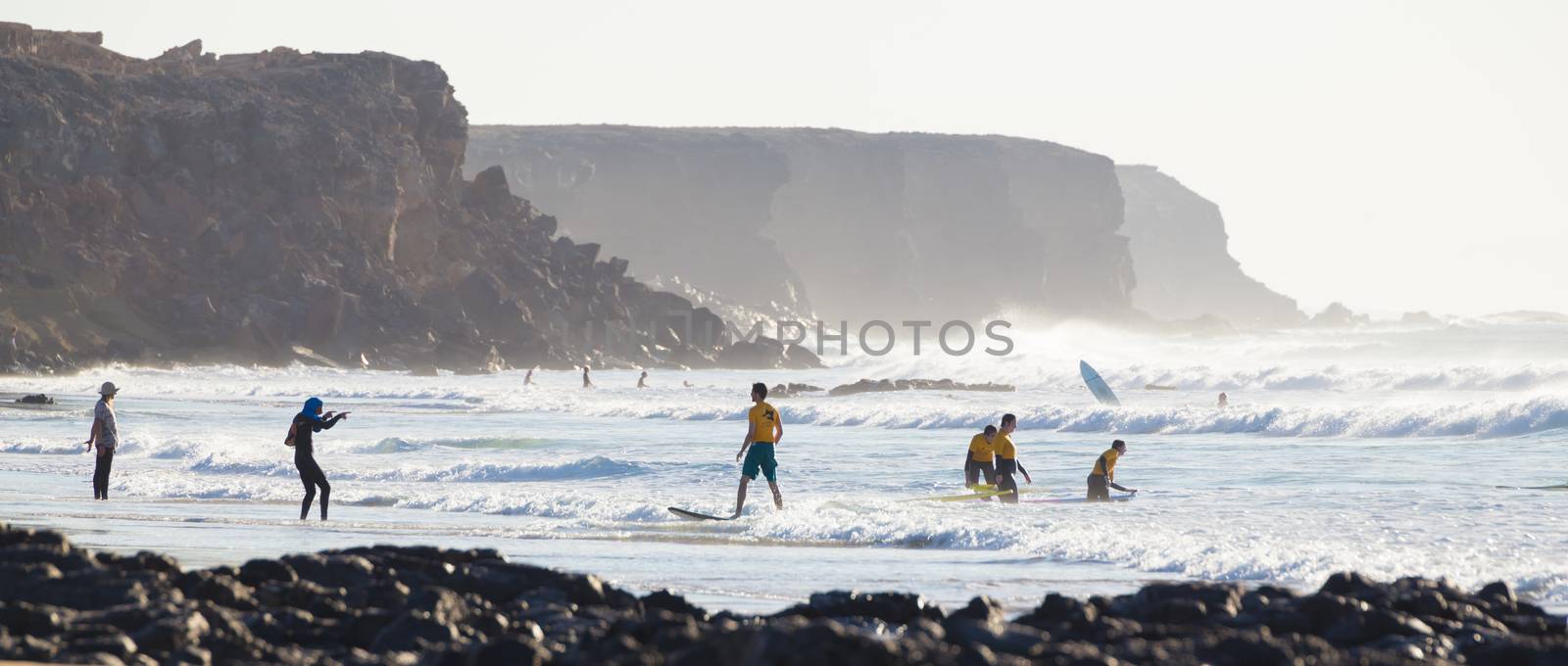 EL Cotillo, Spain - Dec 17, 2015:  Active sporty people having fun learning to surf on El Cotillo beach, famous surfing destination on Fuerteventura, Canary Islands, Spain on December 17, 2015. 