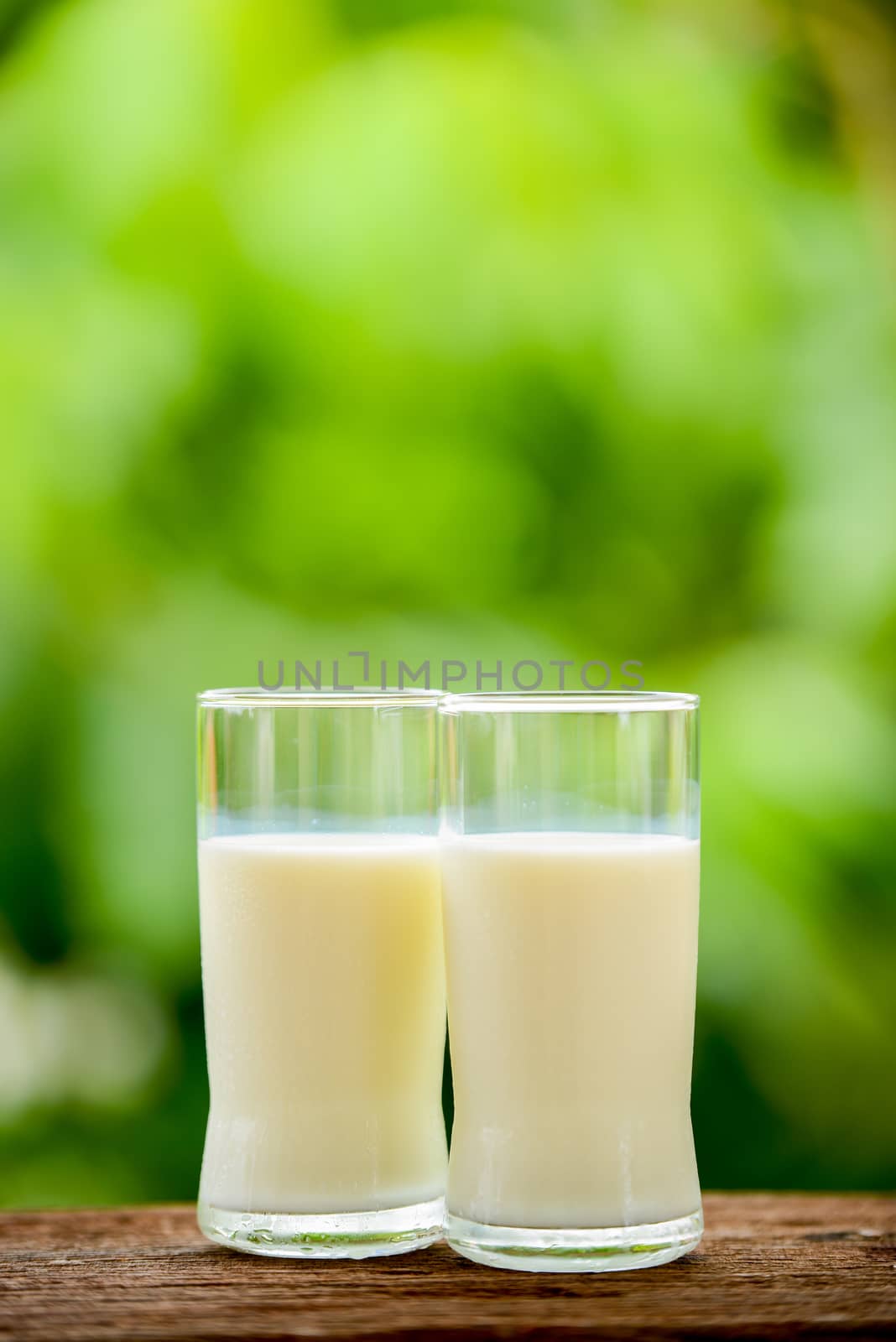 milk glass on table with nature background