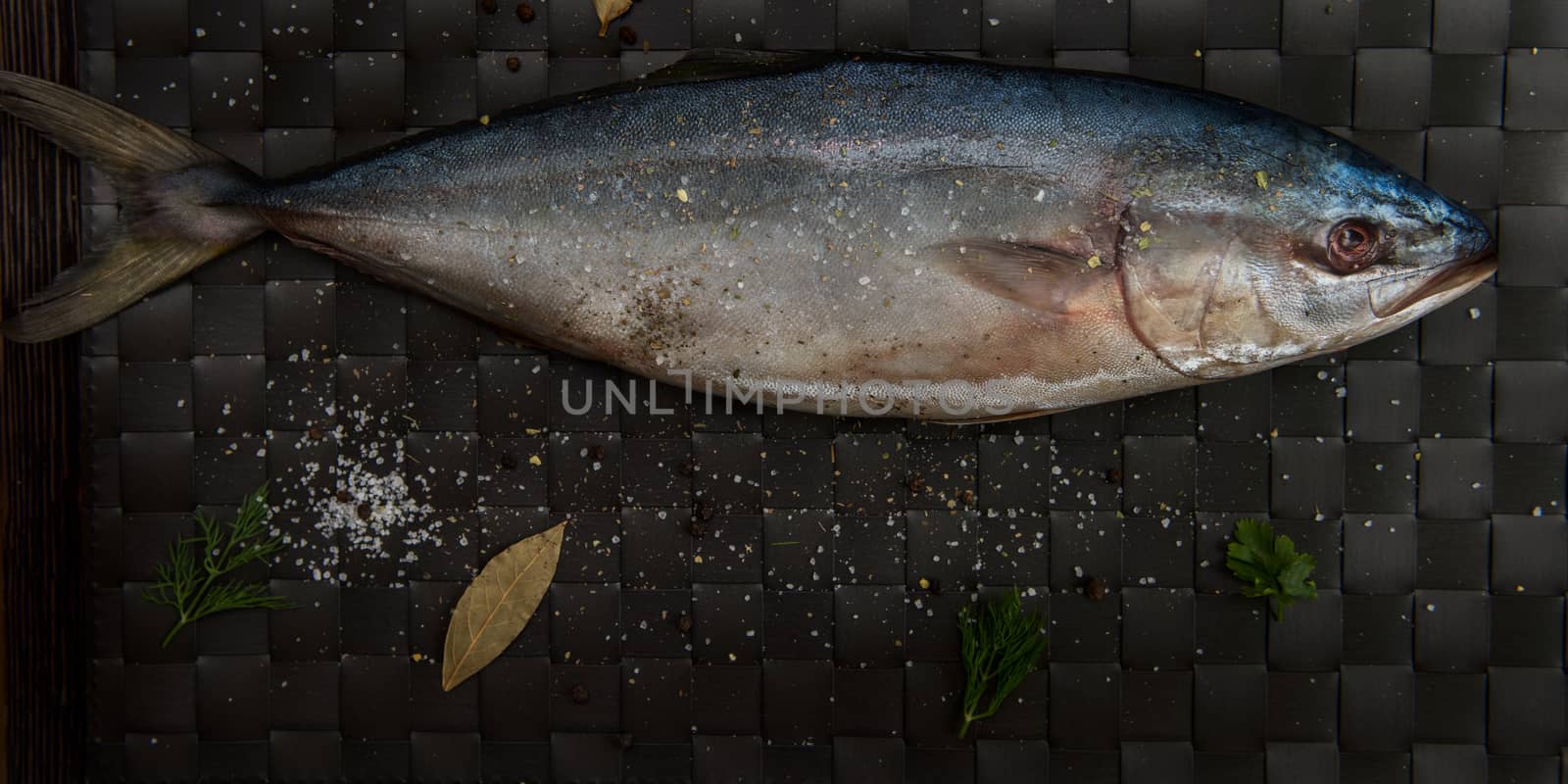 raw tuna fish with salt and spices on black background