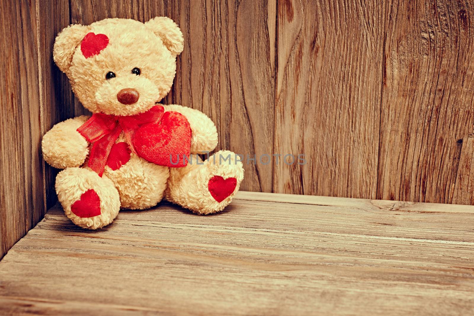 Valentines Day. Teddy Bear Loving cute with red hearts sitting alone waiting for love. Vintage. Retro romantic styled on wooden background. Copyspase