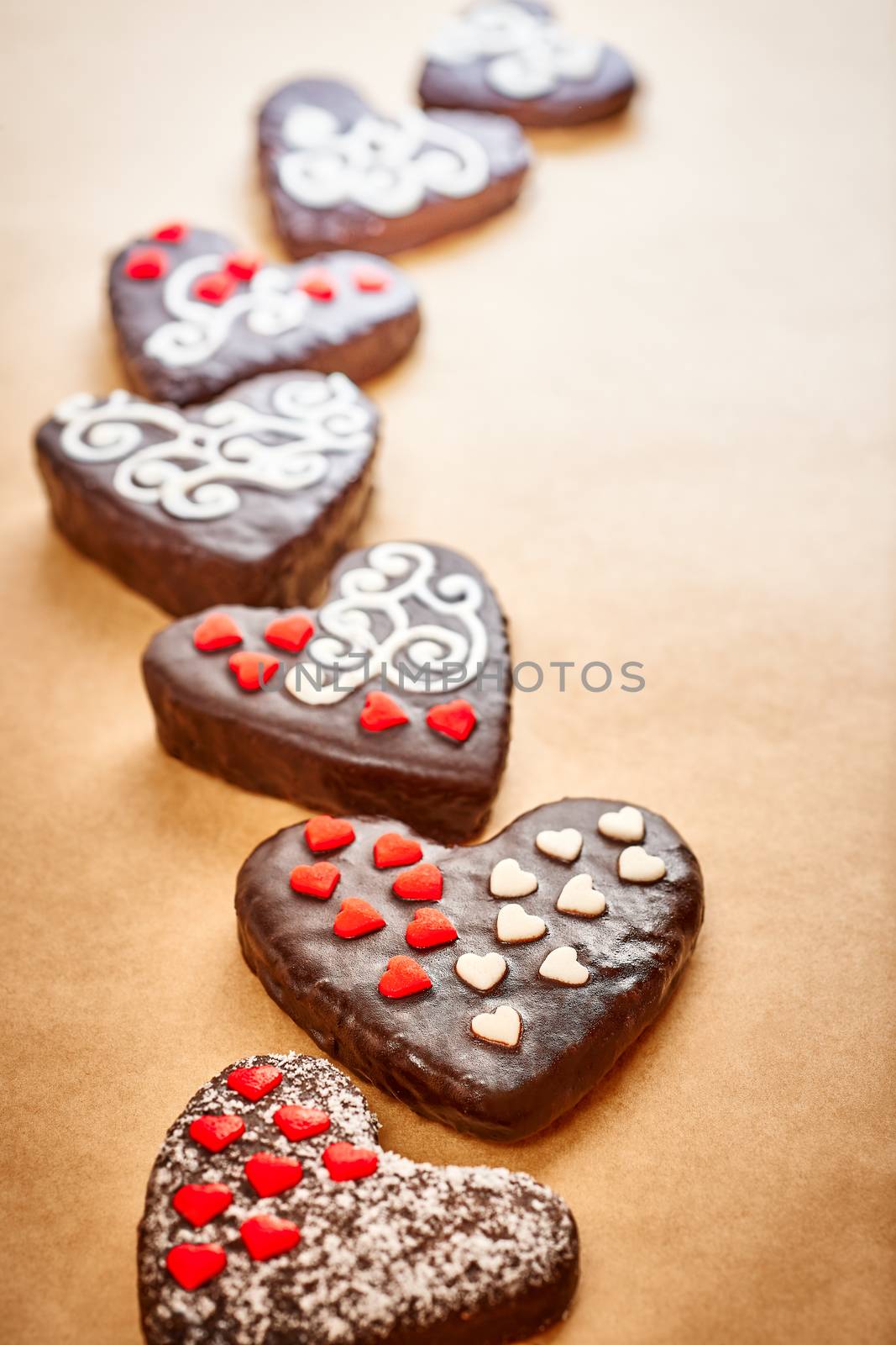 Love, Valentines Day. Hearts Handmade chocolate cakes with decoration on parchment. Romantic sweet unusual creative greeting card