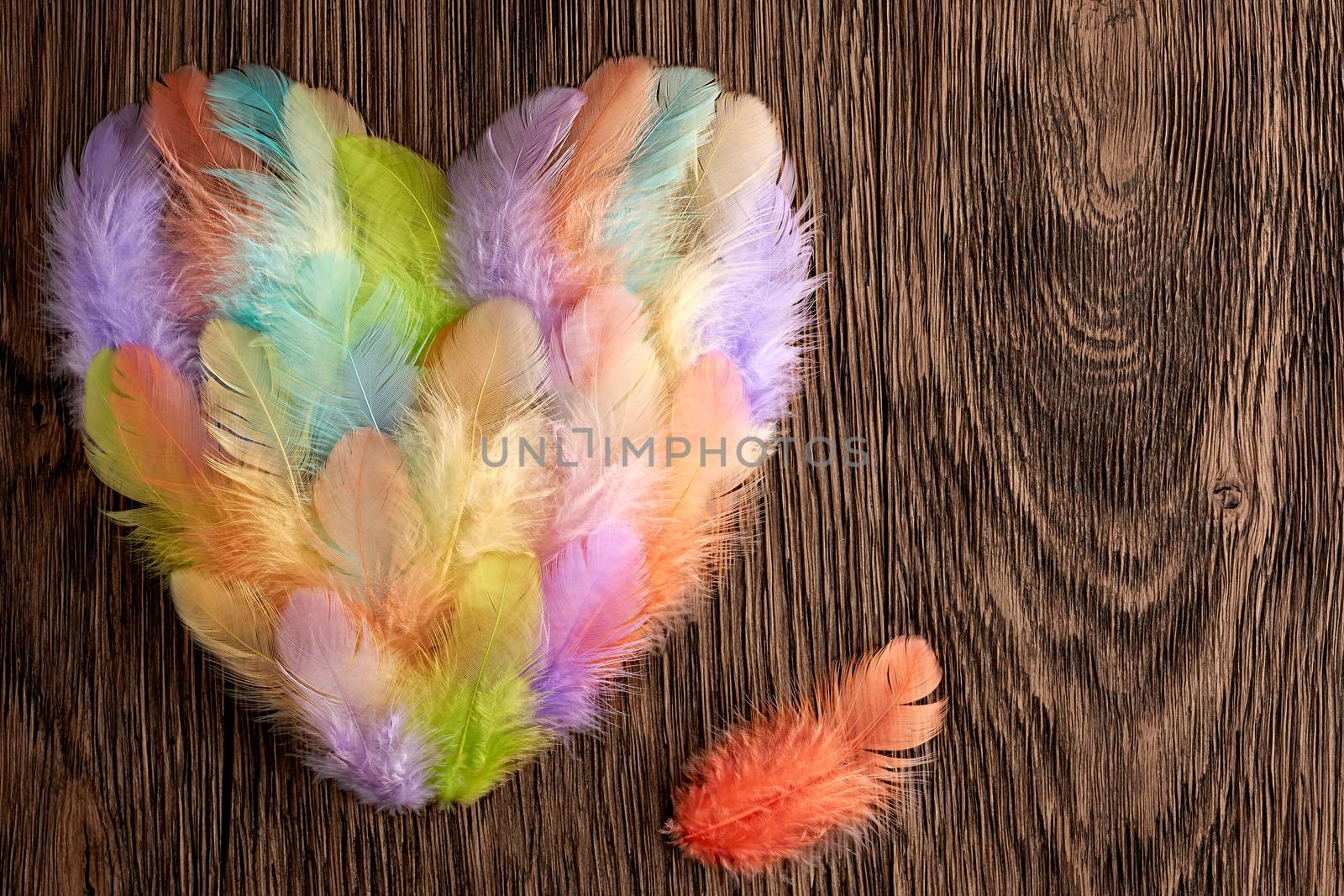 Love, Valentines Day. Heart made of colorful feathers. Retro vintage romantic style on wooden background. Vivid unusual creative greeting card, multicolored, toned, copyspace