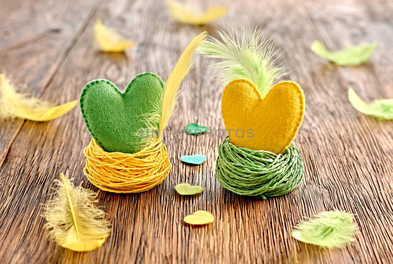 Love hearts handmade on wooden background. Valentines  Day. Couple with feathers in nests. Vintage romantic style. Vivid greeting card, multicolored felt