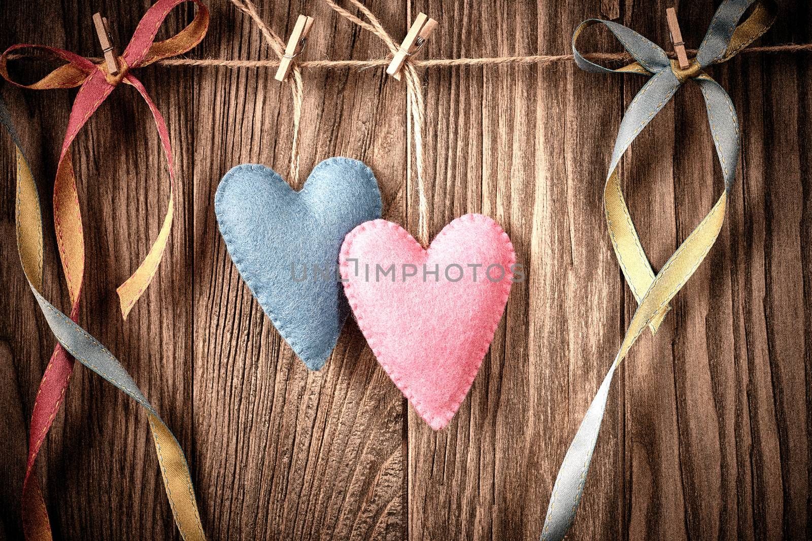 Love hearts, Valentines Day. Hearts couple, handmade, hanging on rope. Vintage retro romantic style on wooden background. Vivid unusual greeting card, multicolored felt, copyspace