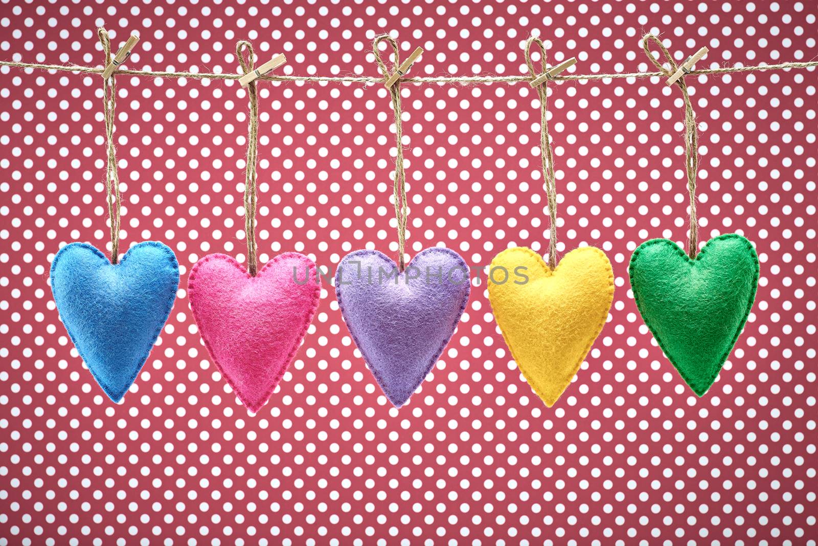 Love hearts, Valentines Day. Hearts set, handmade, hanging on rope. Vintage romantic style on red polka dots. Vivid retro unusual greeting card, multicolored felt, toned, copyspace
