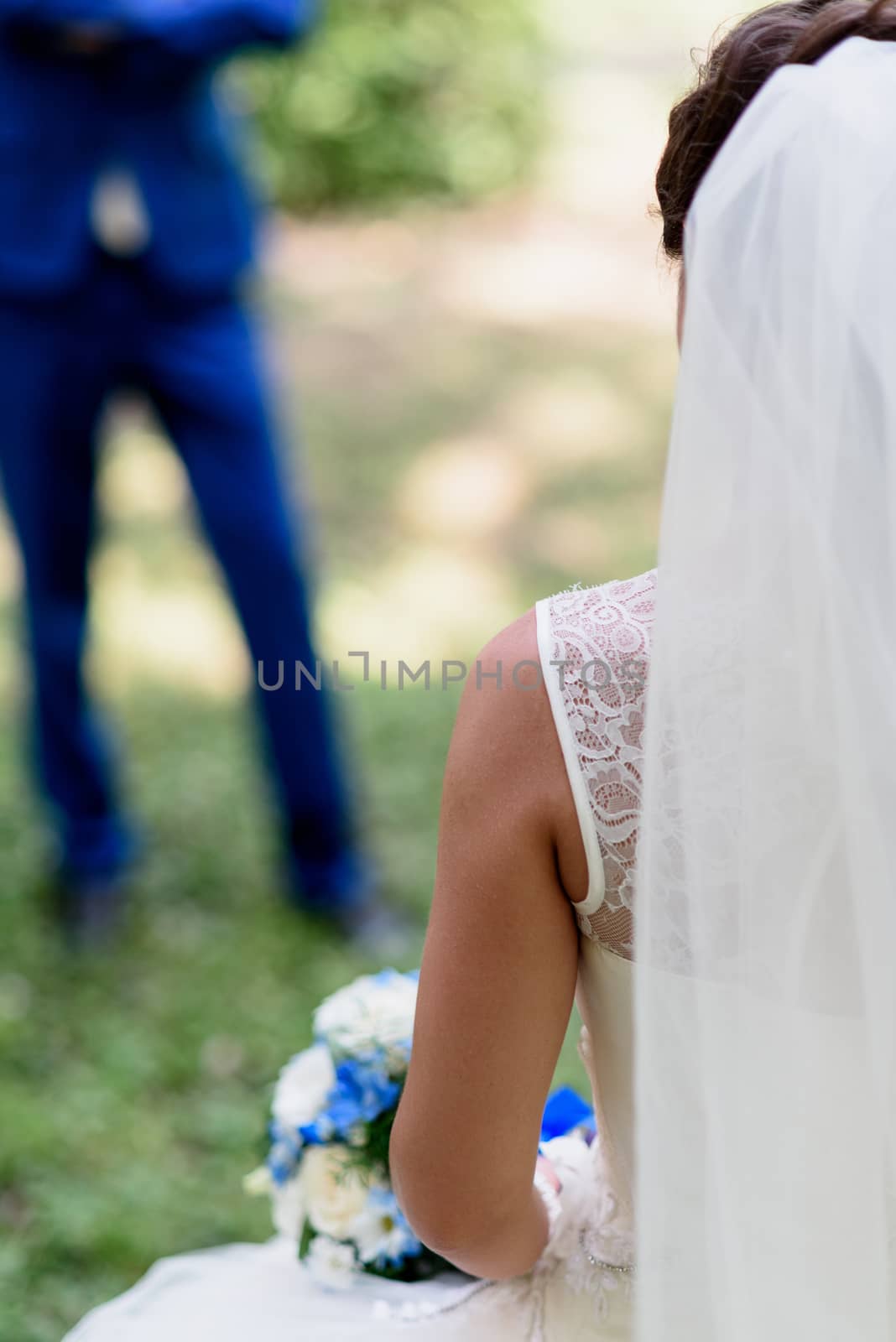 bride holding a bouquet with blue flowers in her hands