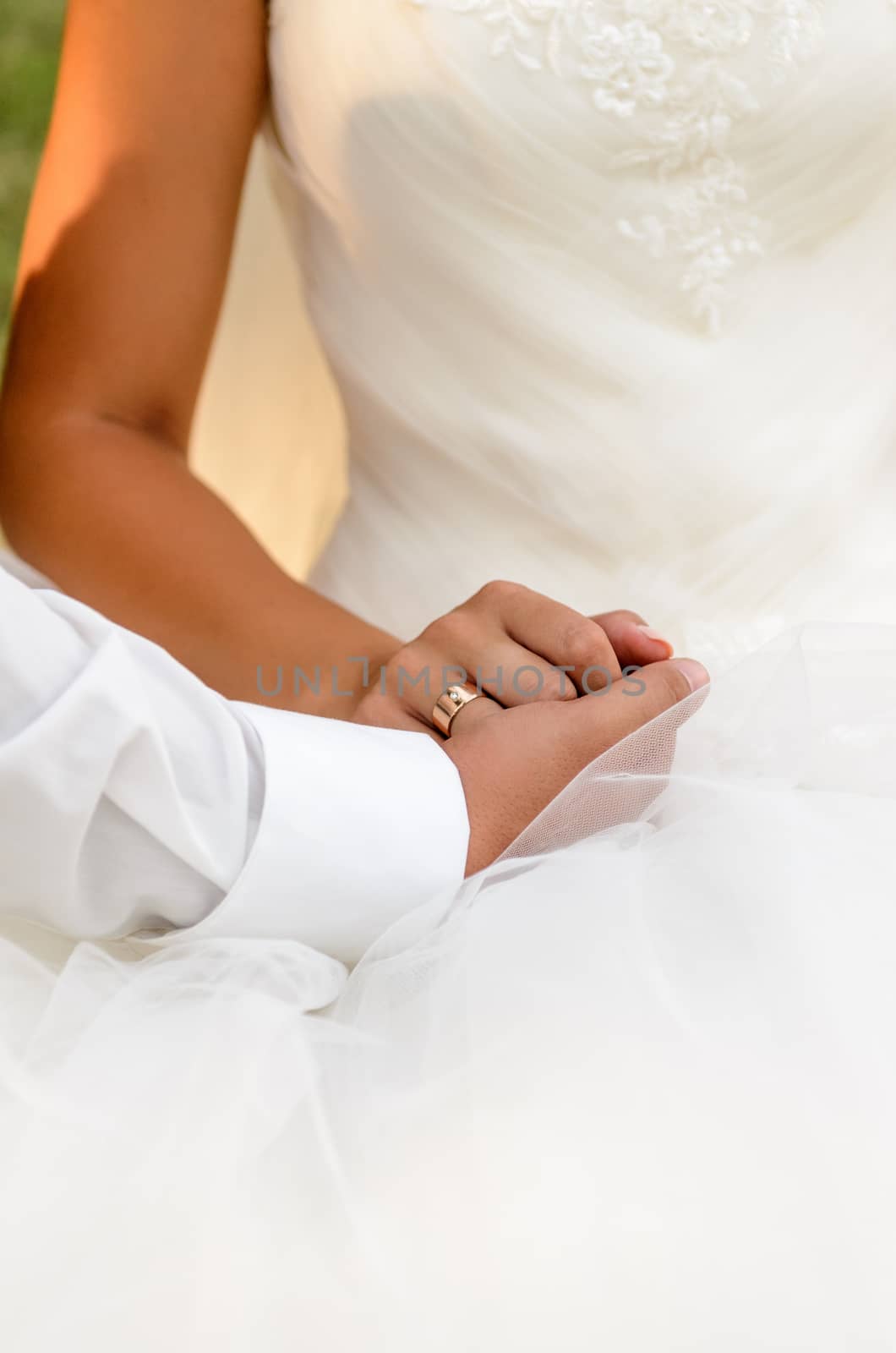 the groom holds his hand over the bride's hand