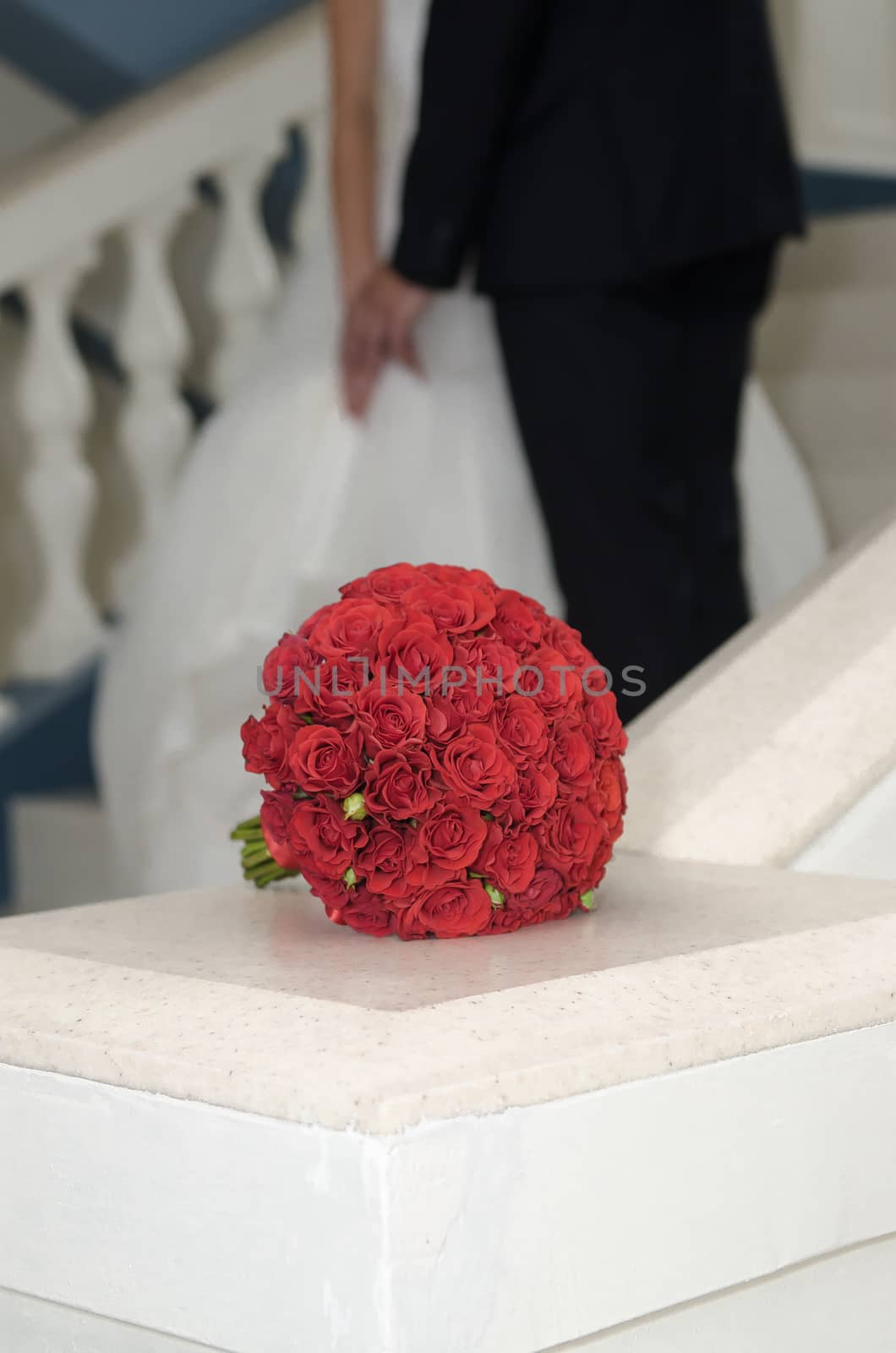 red bouquet of roses on the background of the newlyweds