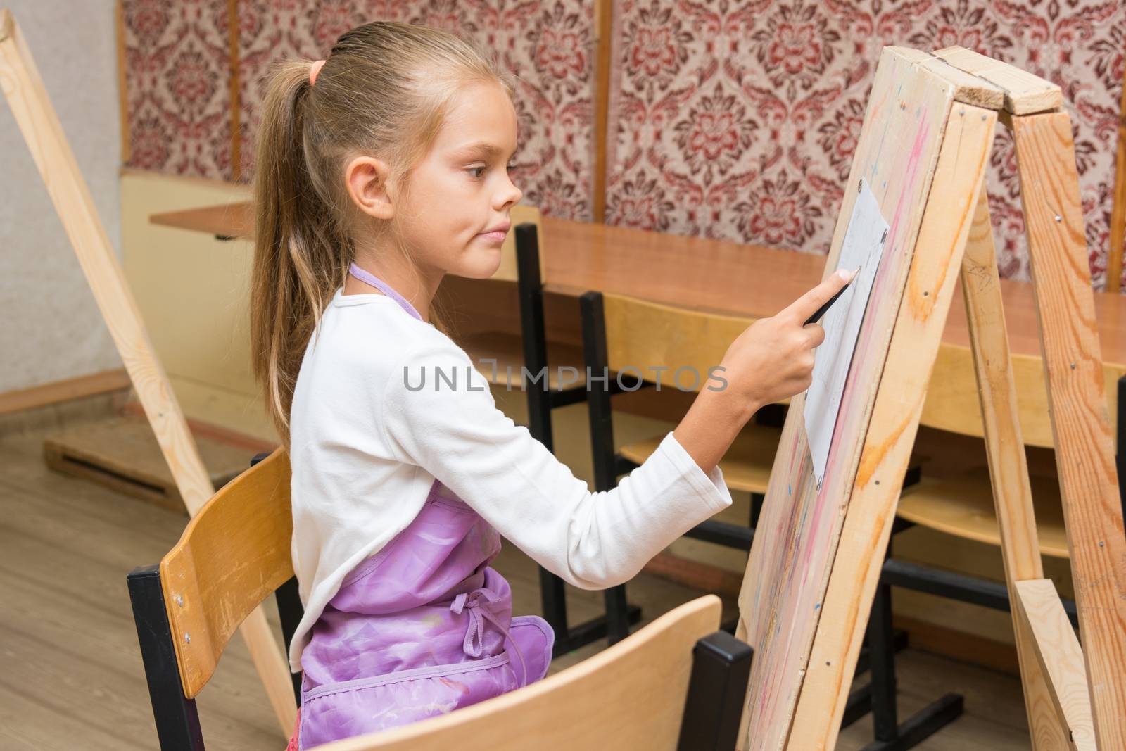 Girl artist with a smile look in the picture on the drawing lesson