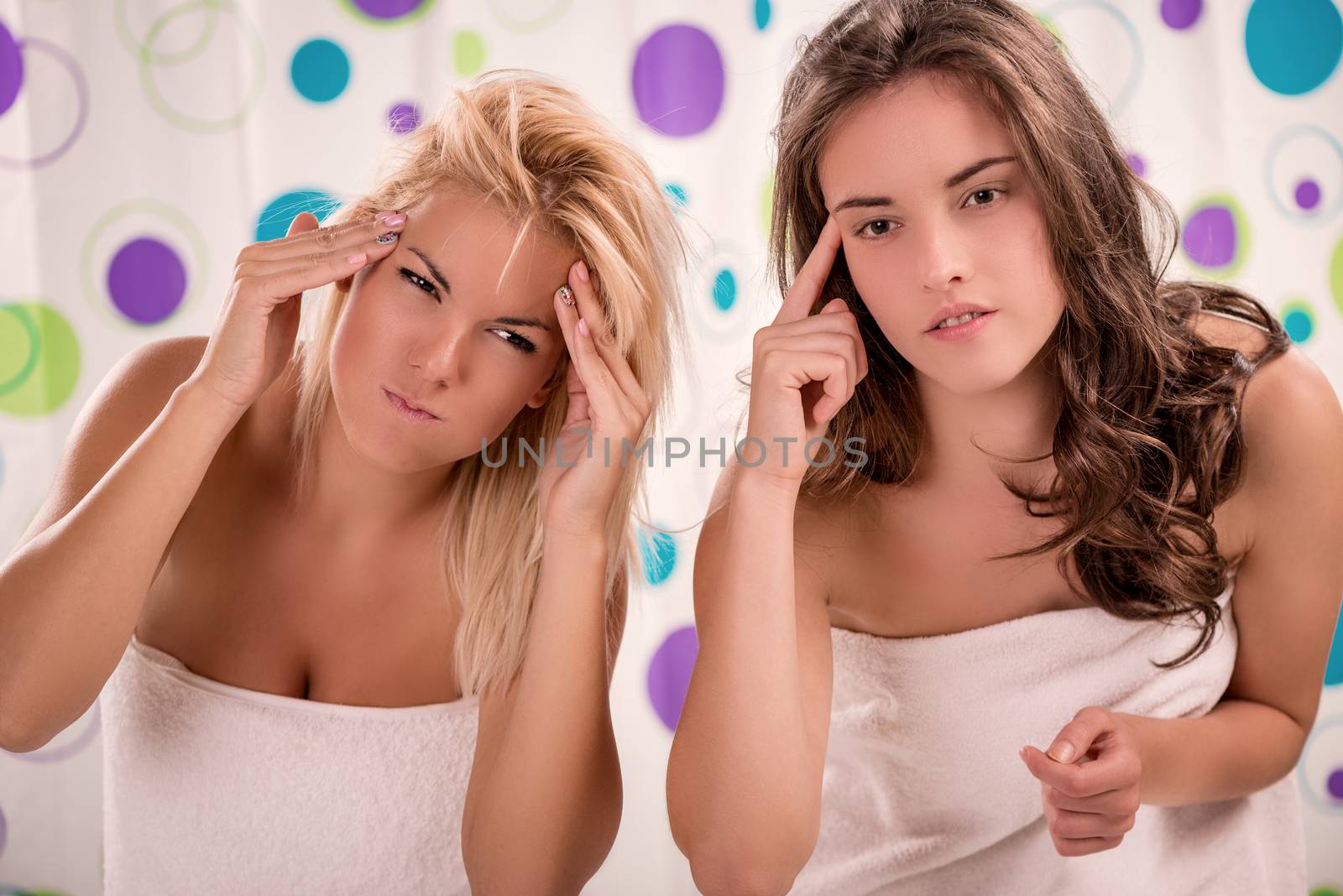 Two young cute woman in front of mirror in bathroom is getting ready to start their day.