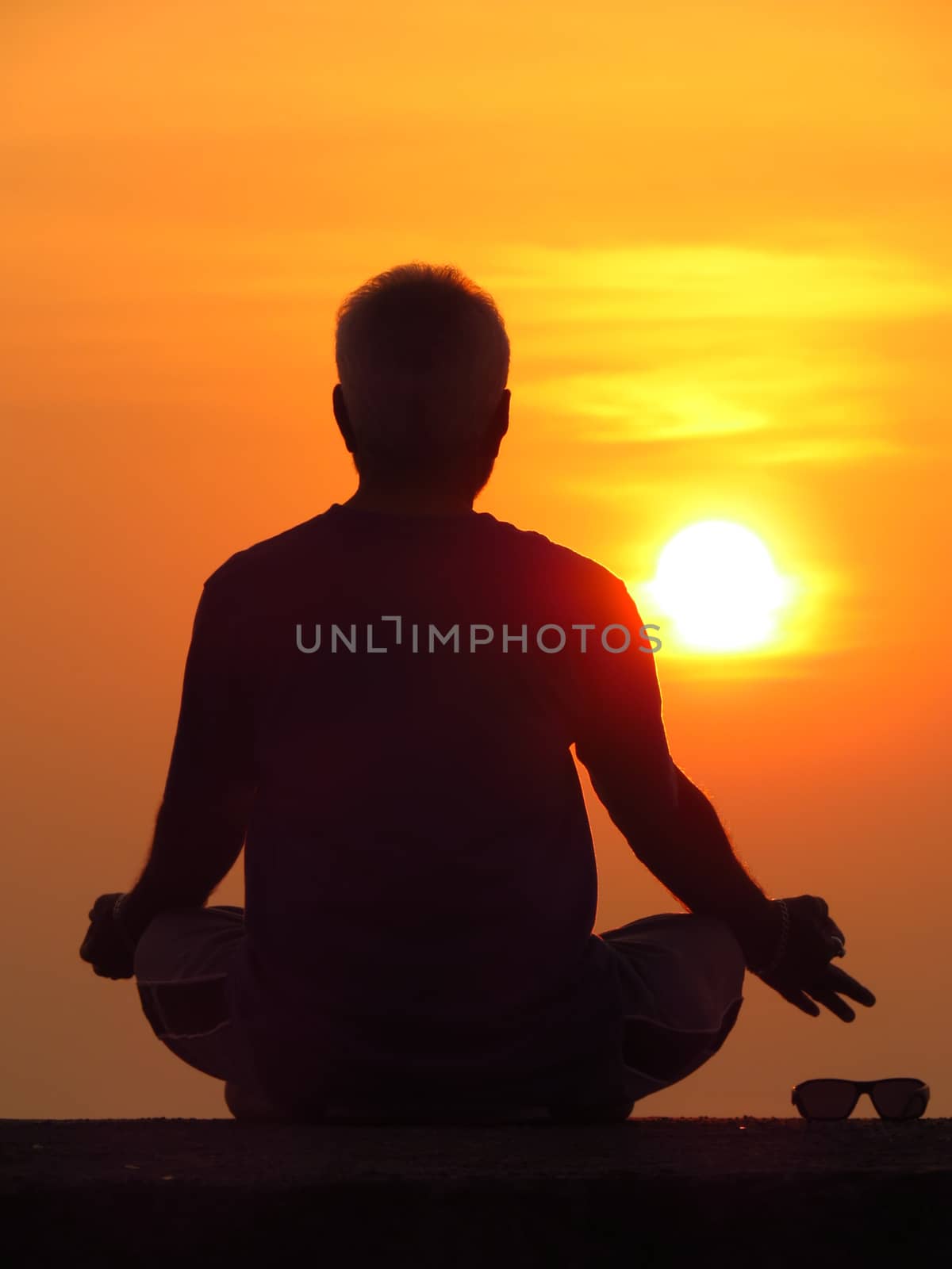 A man meditating against the setting sun a spiritual retreat during the summer holidays                               