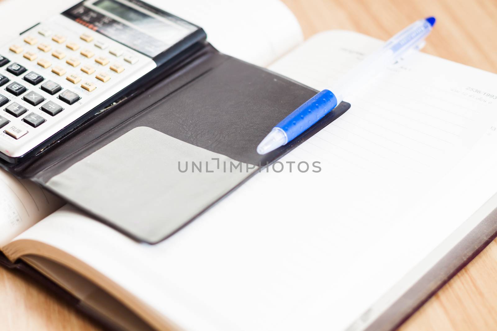 Classic leather notebook with pen and calculator, stock photo