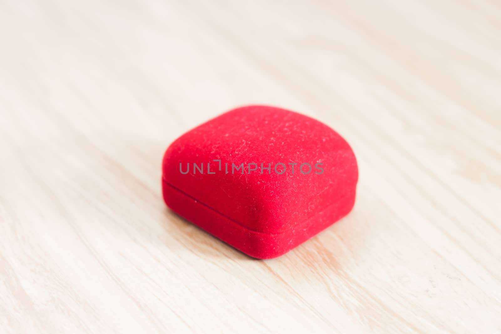 Red ring box on wooden background, stock photo