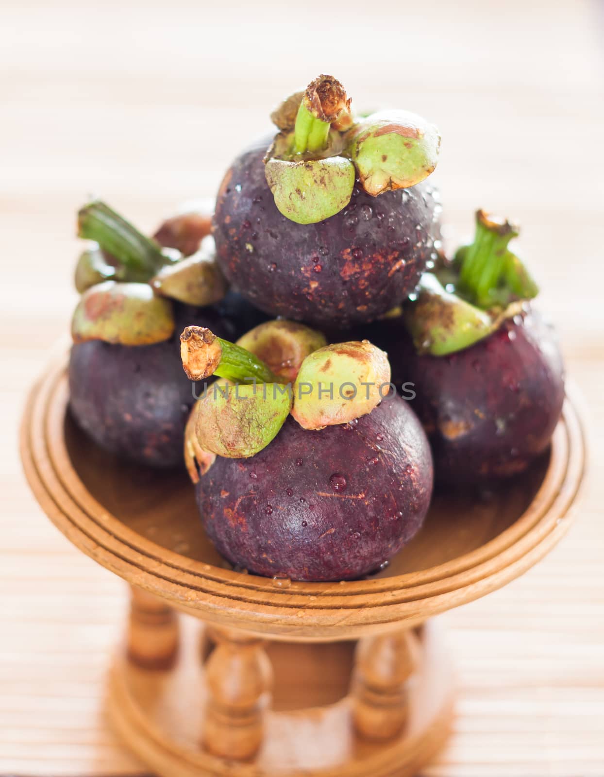 Group of mangoesteen on wooden tray  by punsayaporn