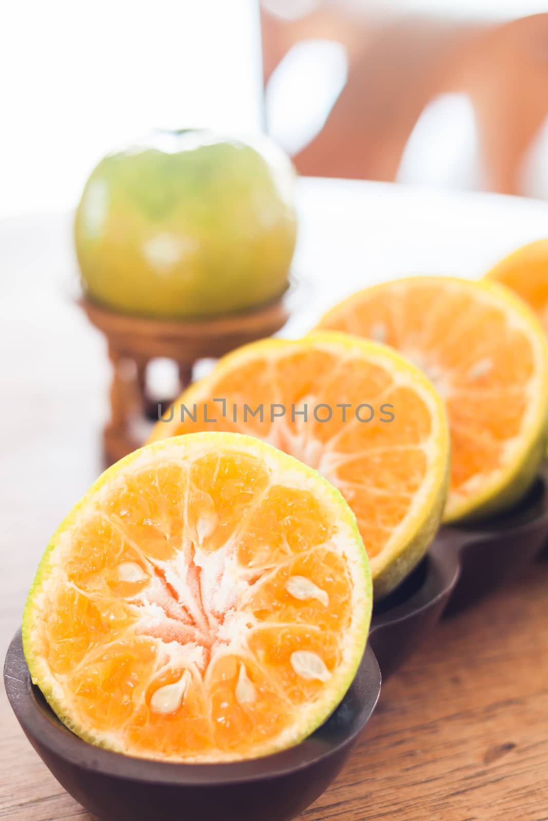 Slice of fresh orange in wooden tray by punsayaporn