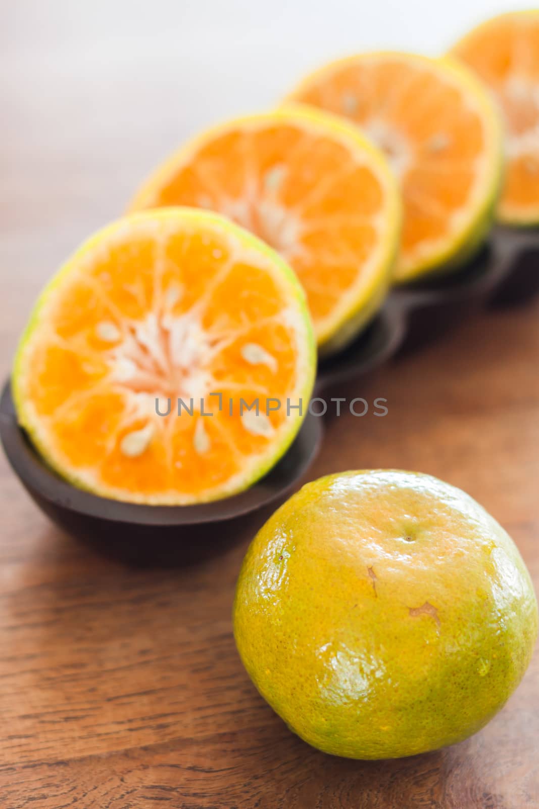 Slice of fresh orange in wooden tray by punsayaporn