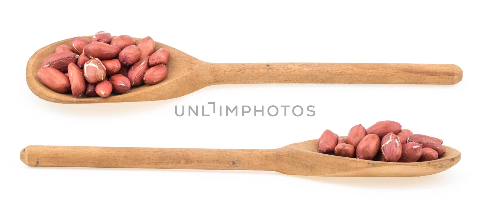 Raw peanuts on wooden spoon isolated on white. Selective focus.
