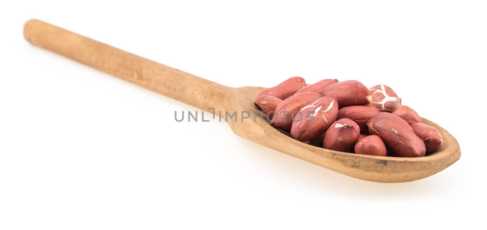 Raw peanuts on wooden spoon isolated on white. Selective focus.