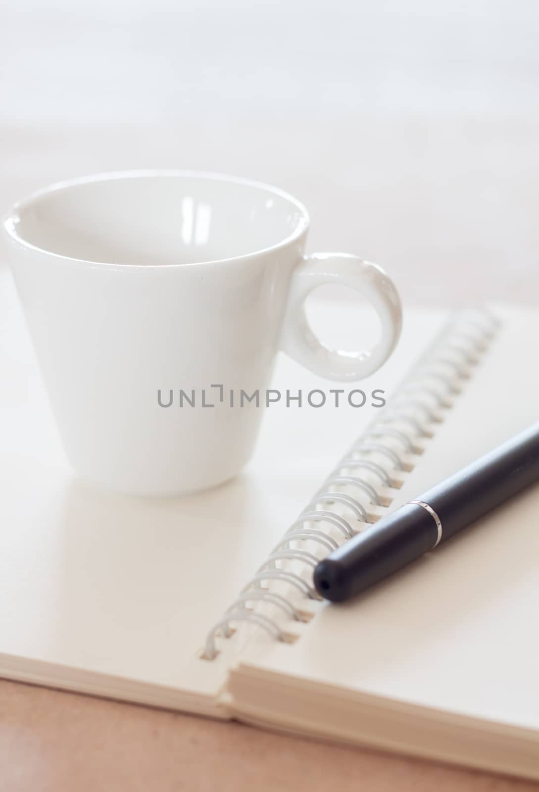 Pen and spiral notebook with coffee cup, stock photo