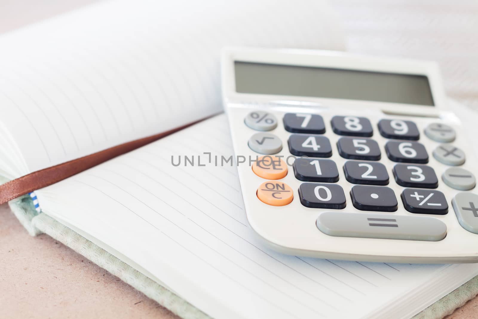 Calculator on blank notebook, stock photo