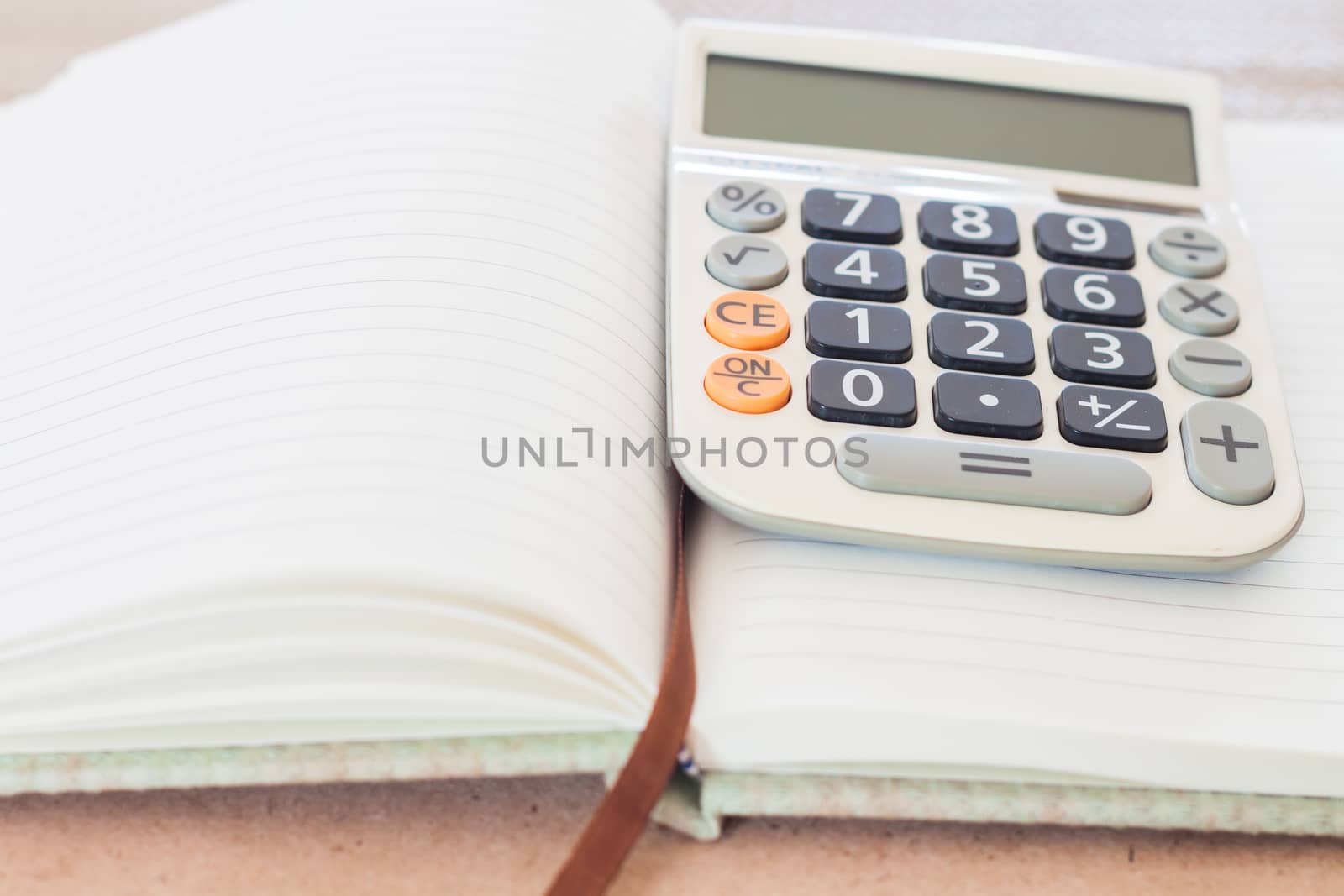 Calculator on blank notebook, stock photo