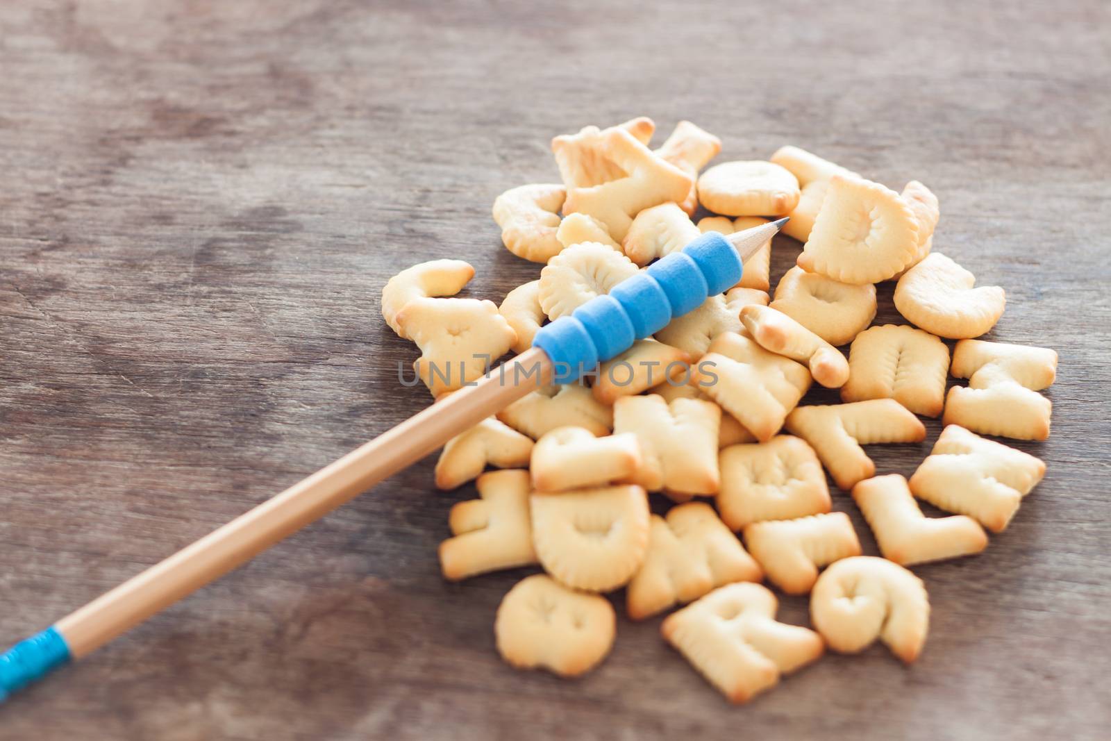 Alphabet biscuit on wooden table, stock photo