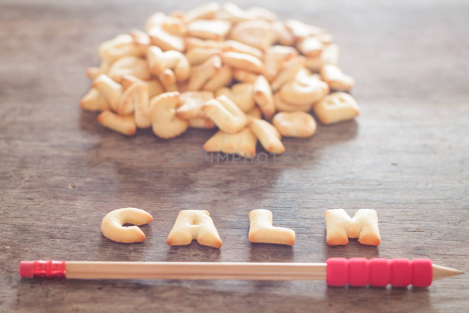 Calm alphabet biscuit on wooden table, stock photo