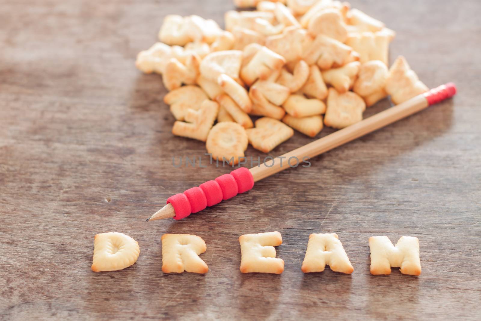 Dream alphabet biscuit on wooden table, stock photo