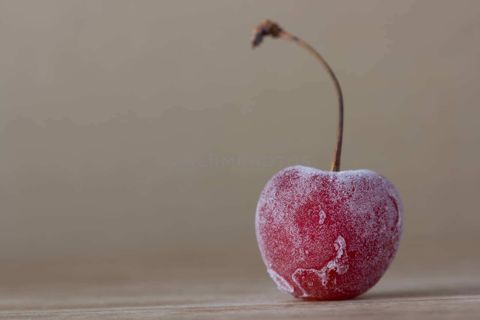 one frozen cherry on wooden background