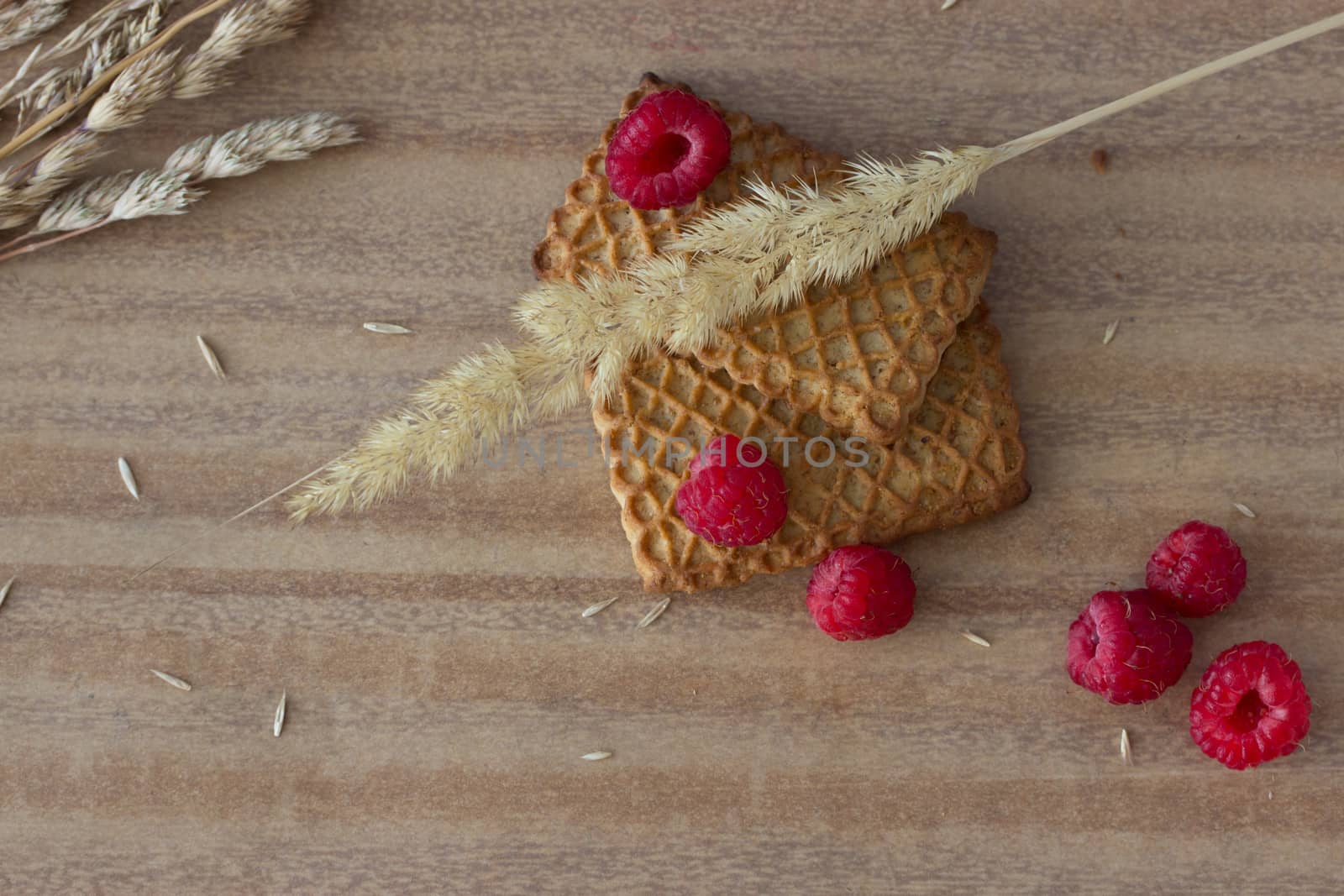 cookies with raspberries and ears on wooden table