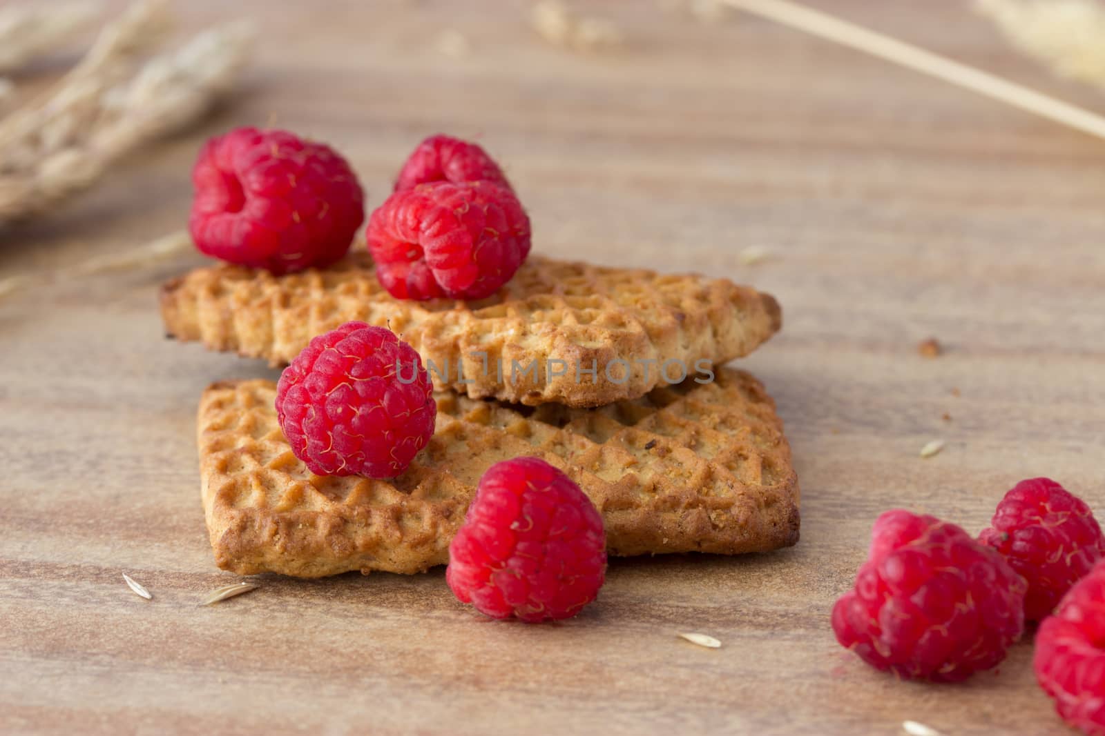 cookies with raspberries and ears on wooden table
