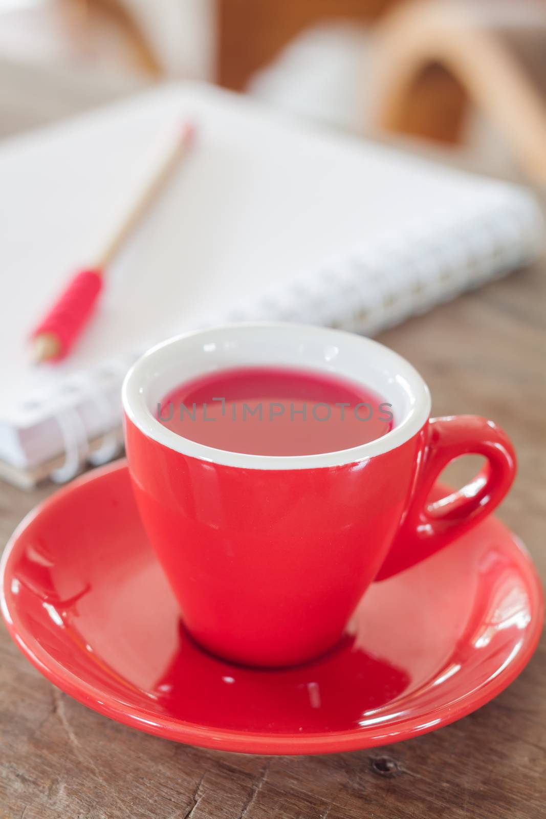 Red mug with open notebook, stock photo