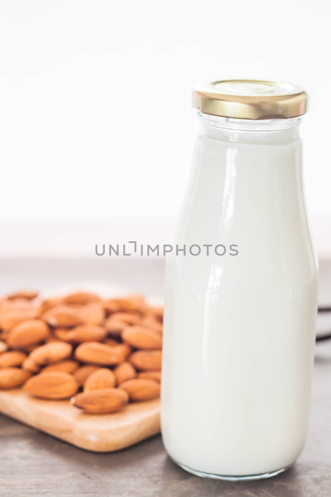 Almond nuts on wooden plate with milk by punsayaporn